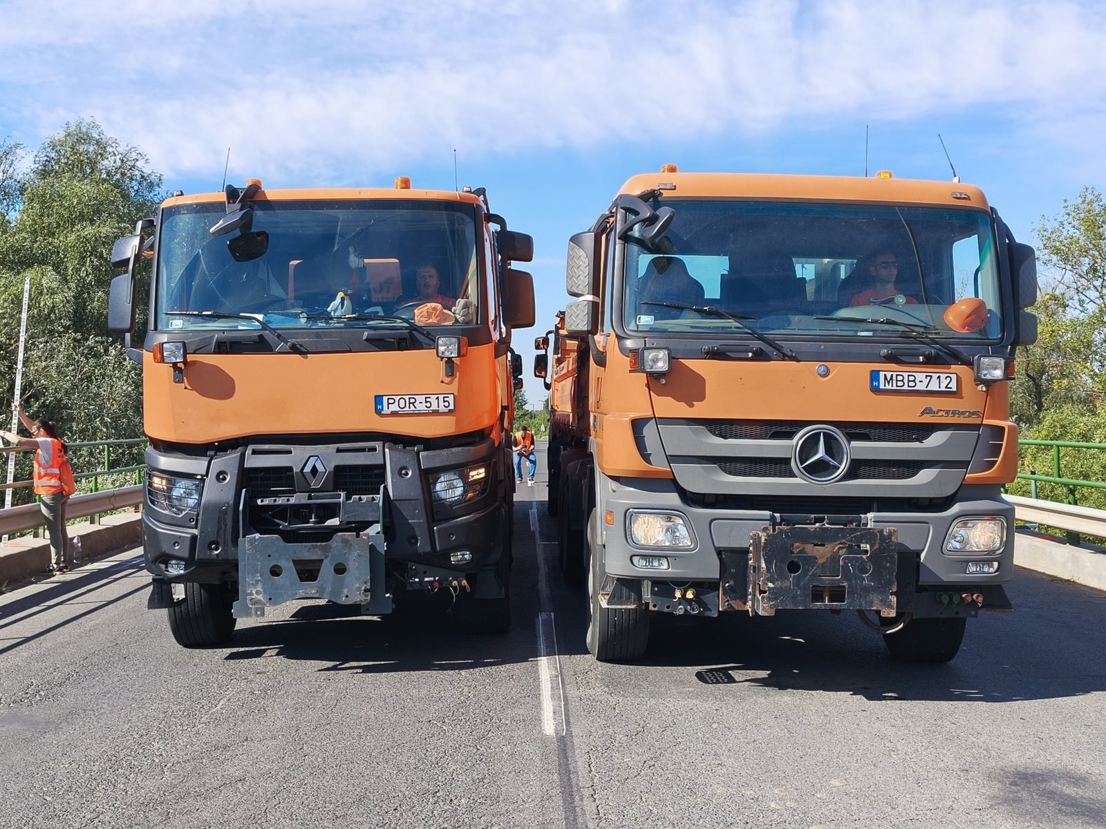 Two weighed trucks side by side on the bridge deck